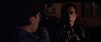 Movie still from “Little Odessa” (1994), directed by James Gray – A man sitting in the back seat of a car looking at another man; Close Up shot, Over the shoulder angle