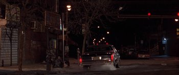 Movie still from “Little Odessa” (1994), directed by James Gray – A car driving down a street at night; Wide shot, Low angle