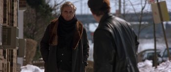 Movie still from “Little Odessa” (1994), directed by James Gray – A man wearing a scarf and a jacket is standing next to another man; Medium shot, Over the shoulder angle