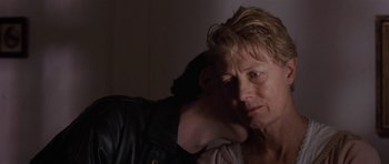 Movie still from “Little Odessa” (1994), directed by James Gray – A man and a woman embracing each other in a dark room; Close Up shot, Over the shoulder angle
