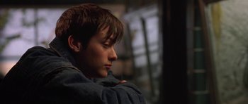 Movie still from “Little Odessa” (1994), directed by James Gray – A young man sitting down with his head resting on his arm; Close Up shot, High angle