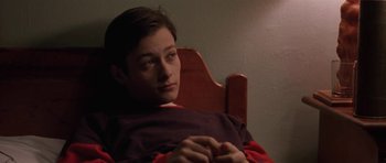 Movie still from “Little Odessa” (1994), directed by James Gray – A man sitting in a wooden chair in a dark room; Close Up shot, High angle