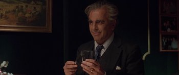 Movie still from “Little Odessa” (1994), directed by James Gray – An older man in a suit holding a glass of water; Close Up shot, Over the shoulder angle