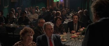 Movie still from “Little Odessa” (1994), directed by James Gray – A group of people sitting at a table with food; Medium shot, High angle