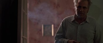 Movie still from “Little Odessa” (1994), directed by James Gray – A man standing in front of a brick wall with smoke coming out of his mouth; Close Up shot, Low angle