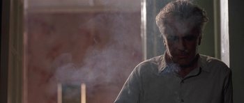 Movie still from “Little Odessa” (1994), directed by James Gray – An older man standing in front of a window with steam coming out of the window; Medium shot, Low angle
