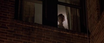 Movie still from “Little Odessa” (1994), directed by James Gray – A man looking out of a window at night; Medium shot, Low angle
