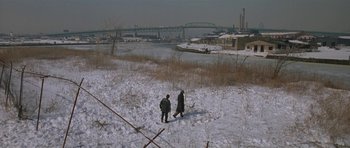 Movie still from “Little Odessa” (1994), directed by James Gray – Two people walking across a snow covered field; Extreme Wide shot, High angle