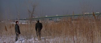 Movie still from “Little Odessa” (1994), directed by James Gray – A man wearing a hat walking through a field; Extreme Wide shot, High angle