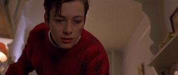 Movie still from “Little Odessa” (1994), directed by James Gray – A boy in a red sweater looking down at the floor; Close Up shot, Low angle