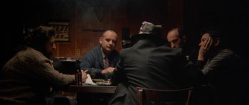 Movie still from “Little Odessa” (1994), directed by James Gray – A group of men sitting at a table with food; Medium shot, Over the shoulder angle