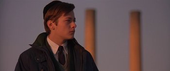 Movie still from “Little Odessa” (1994), directed by James Gray – A man in a suit and tie standing in front of a building; Close Up shot, Low angle