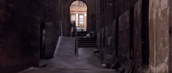 Movie still from “Little Odessa” (1994), directed by James Gray – A man walking down a set of stairs in an alleyway; Extreme Wide shot, High angle