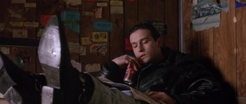 Movie still from “Little Odessa” (1994), directed by James Gray – A man sitting in a room holding a can of beer; Medium shot, High angle