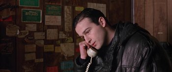 Movie still from “Little Odessa” (1994), directed by James Gray – A man in a leather jacket talking on a phone; Close Up shot, High angle
