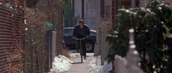 Movie still from “Little Odessa” (1994), directed by James Gray – A man riding a bike down a snow covered sidewalk; Wide shot, High angle