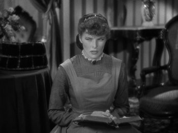 Movie still from “Little Women” (1933), directed by George Cukor – A woman sitting in a chair reading a book; Close Up shot, High angle