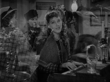 Movie still from “Little Women” (1933), directed by George Cukor – A black - and - white photo of a woman sitting at a piano; Medium shot, High angle