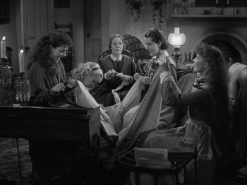 Movie still from “Little Women” (1933), directed by George Cukor – A group of people sitting around a table; Medium shot, High angle