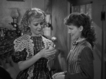 Movie still from “Little Women” (1933), directed by George Cukor – Two women are talking and one of them is holding an object in her hand; Medium shot, High angle