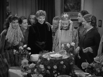 Movie still from “Little Women” (1933), directed by George Cukor – A group of people standing around a cake; Medium shot, High angle