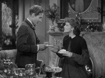 Movie still from “Little Women” (1933), directed by George Cukor – A man and a woman are holding plates of food; Medium shot, High angle