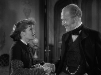 Movie still from “Little Women” (1933), directed by George Cukor – An older man and a young woman shaking hands; Medium shot, Over the shoulder angle