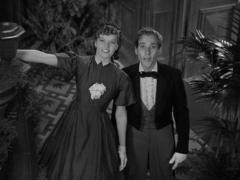 Movie still from “Little Women” (1933), directed by George Cukor – A man and a woman standing next to each other in front of a building; Medium shot, High angle