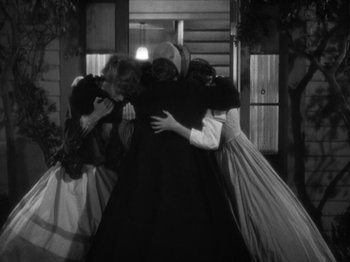 Movie still from “Little Women” (1933), directed by George Cukor – A group of people in period dress hugging; Wide shot, High angle