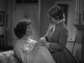 Movie still from “Little Women” (1933), directed by George Cukor – Two women are holding each other in a room; Medium shot, High angle