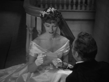 Movie still from “Little Women” (1933), directed by George Cukor – An old photo of a man and a woman sitting in a chair; Medium shot, High angle