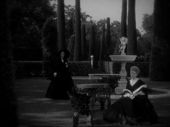Movie still from “Little Women” (1933), directed by George Cukor – Two women sitting on a bench in a garden; Wide shot, High angle