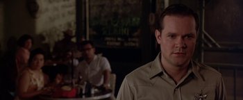 Movie still from “Lone Star” (1996), directed by John Sayles – A man standing in front of another man in front of a table; Close Up shot, Over the shoulder angle