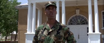 Movie still from “Lone Star” (1996), directed by John Sayles – A man in a military uniform standing in front of a building; Medium shot, Low angle