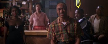 Movie still from “Lone Star” (1996), directed by John Sayles – A man and a woman are standing at a bar; Medium shot, Low angle