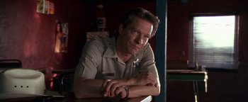 Movie still from “Lone Star” (1996), directed by John Sayles – A person sitting at a table with his arms crossed; Close Up shot, Low angle