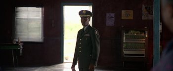 Movie still from “Lone Star” (1996), directed by John Sayles – A man in a military uniform standing in front of an open door; Medium shot, Low angle