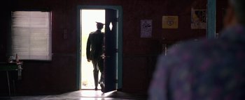 Movie still from “Lone Star” (1996), directed by John Sayles – A man in uniform walking through a door way; Wide shot, Over the shoulder angle