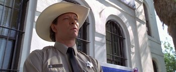 Movie still from “Lone Star” (1996), directed by John Sayles – A man in a sheriff's uniform and a cowboy hat; Close Up shot, Low angle