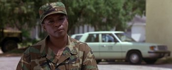 Movie still from “Lone Star” (1996), directed by John Sayles – A man in military fatigues standing in front of a car; Close Up shot, Low angle