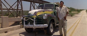 Movie still from “Lone Star” (1996), directed by John Sayles – A man standing in front of an old truck; Wide shot, Low angle