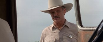 Movie still from “Lone Star” (1996), directed by John Sayles – A man in a cowboy hat and a sheriff's badge; Close Up shot, Low angle