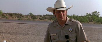 Movie still from “Lone Star” (1996), directed by John Sayles – A man wearing a white cowboy hat standing on a dirt road; Close Up shot, Low angle