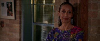 Movie still from “Lone Star” (1996), directed by John Sayles – An older woman wearing a purple shirt and a pair of ear buds; Close Up shot, Over the shoulder angle