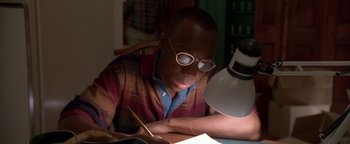 Movie still from “Lone Star” (1996), directed by John Sayles – A young man is writing at a desk; Close Up shot, High angle