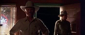 Movie still from “Lone Star” (1996), directed by John Sayles – A man in a cowboy hat standing next to another man; Medium shot, Low angle