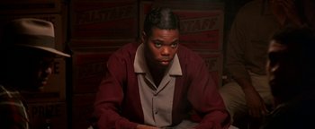 Movie still from “Lone Star” (1996), directed by John Sayles – A man sitting in front of a wall of boxes; Close Up shot, Low angle