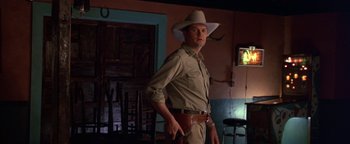 Movie still from “Lone Star” (1996), directed by John Sayles – A man wearing a cowboy hat and holding a gun; Medium shot, Low angle