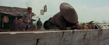 Movie still from “Lone Wolf and Cub: Baby Cart to Hades” (1972), directed by Kenji Misumi – A man with a hat is laying on the ground; Wide shot, High angle