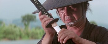 Movie still from “Lone Wolf and Cub: Baby Cart to Hades” (1972), directed by Kenji Misumi – An older man holding a sword in his hands; Close Up shot, Low angle